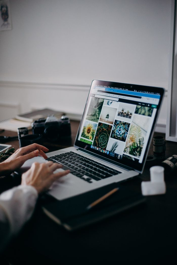 A creative workspafeaturing a laptop displaying a gallery of images, ideal for digital nomads and remote work.